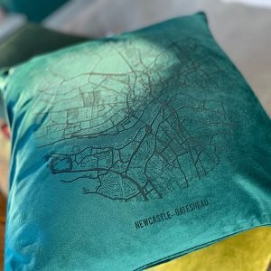A fabulous teal coloured velvet cushion with a map of Newcastle and Gateshead imprinted on it.