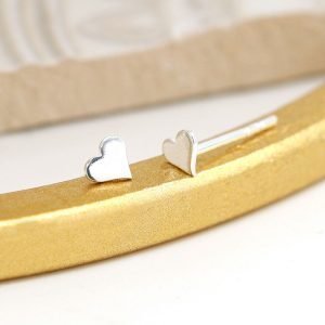 A pair of tiny sterlind silver heart stud earrings.