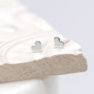 A pair of tiny sterlind silver heart stud earrings.