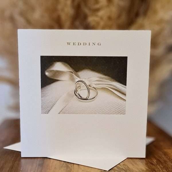 A wedding card with a photograph of 2 wedding rings