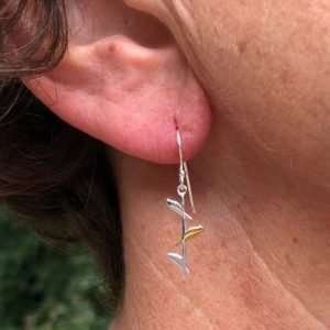 A stunning pair of sterling silver earrings with a long stick with three little birds on them. The middle bird is gold plated.