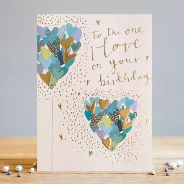 A lovely card from designer Louise Tiler with an image of two blue heart shaped balloons with the words To the One I Love on YOur Birthday printed on it.