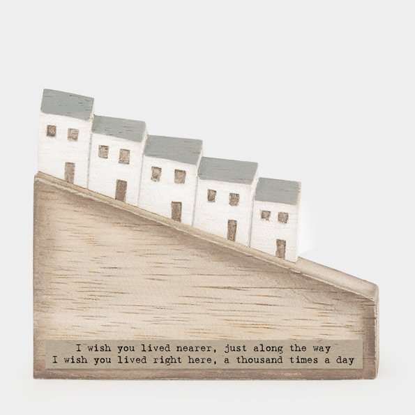 A sweet little wooden scene decoration with a row of white houses and the words 'I wish you lived nearer, just along the way. I wish you lived right here, a thousand times a day