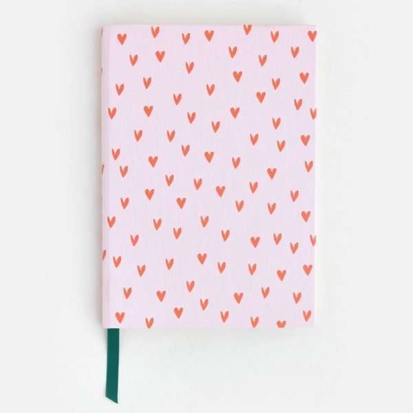 Mini Hearts Casebound Notebook. A hardback metallic leather-look notebook in pink with mini red hearts. The inside cover is decorated with big black and white hearts. There is an inner pocket and the pages are ruled