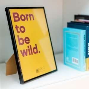 A yellow print with the words Born To Be Wild printed in a pink shimmer effect and with a QR code on the bottom of it that allows you to play the song on a Smart phone.