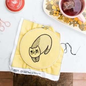 A lovely cat design embroidery kit with mustard coloured material with all of the materials, needles, threads and pattern to make this lovely wall hanging.