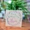 A mother's day card with a floral wreath and Happy Mother's day Mam
