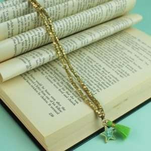 A gold bead long necklace with a apple green enamel star pendant and a green and gold tassel