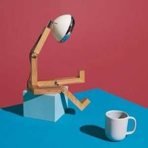 A fun wooden hand made lamp. Made from ash wood with moveable joints and with a vespa style headlamp fixing.