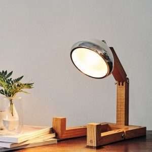 A fun wooden hand made lamp. Made from ash wood with moveable joints and with a vespa style headlamp fixing.