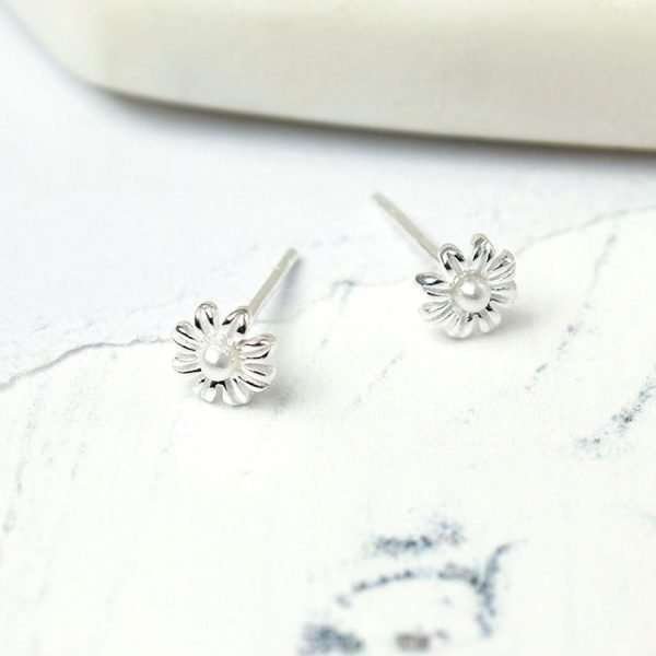 A pair of small flower stud earrings with a tiny pearl centre