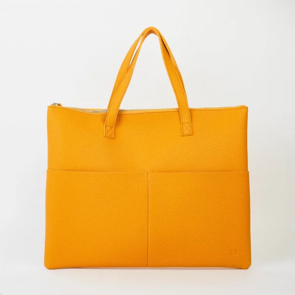 A lovely mustard yellow tote bag that is made from vegan leather. It has short handles and two pockets on the front of it.