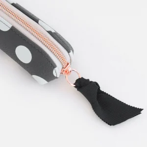 Charcoal Spot Pencil Case. A charcoal grey pencil case with white spots, a contrasting spotty lining and rose gold zip fastening with black grosgrain ribbon zip pull