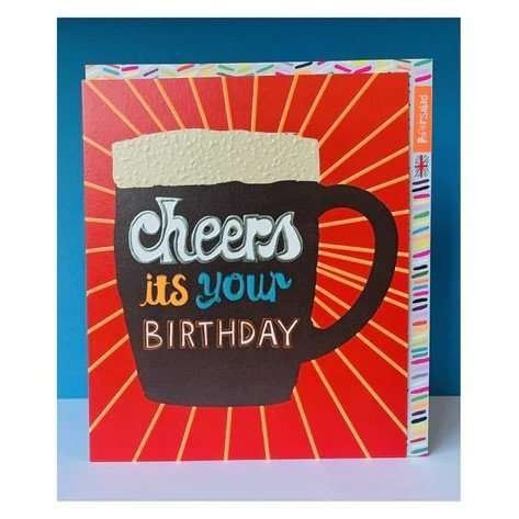 A red card with radiating beams from a beer glass with the words Cheers its your birthday. Full of bright neon colours, patterned textures and lovely foil.