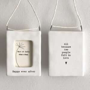 A sweet little white ceramic frame, with string hanger. The words Happy Ever After are written on the front of it. The words 'All because two people fell in love are on the back of the frame