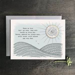A lovely card with fields and the sun and the words Those we love don't go away they walk beside us every day, unseen, unheard but always near, still loved, still missed and very dear.