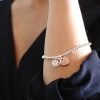 Stretch bracelet made from little round silver plated beads, with a mixed metallic daisy circle charm and rose gold style heart charm in a matt finish.