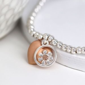 Stretch bracelet made from little round silver plated beads, with a mixed metallic daisy circle charm and rose gold style heart charm in a matt finish.