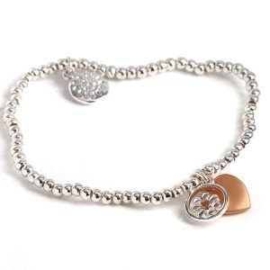 Stretch bracelet made from little round silver plated beads, with a mixed metallic daisy circle charm and rose gold style heart charm in a matt finish.