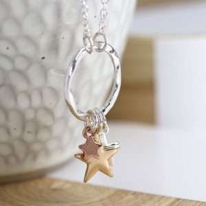 Triple Star Necklace. Silver plated split chain necklace with a hammered silver plated hoop pendant and three star charms of different sizes in contrasting silver, gold and rose gold style finishes. This necklace is fastened with a lobster clasp and has an extension chain to adjust the length.