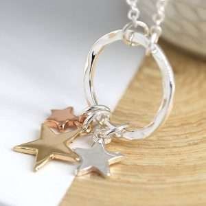 Triple Star Necklace. Silver plated split chain necklace with a hammered silver plated hoop pendant and three star charms of different sizes in contrasting silver, gold and rose gold style finishes. This necklace is fastened with a lobster clasp and has an extension chain to adjust the length.