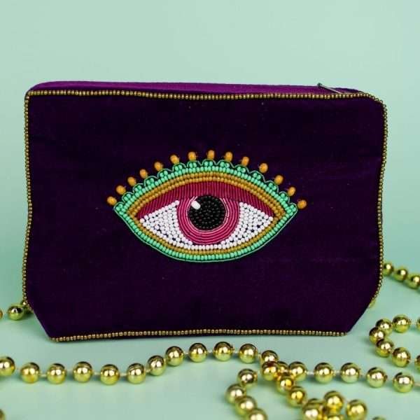 A plum velvet coin purse with a beaded eye motif