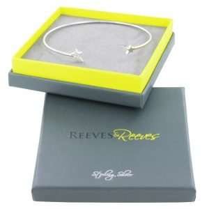 A sterling silver cuff style bracelet with 2 stars. Set with two stars, one in a wonderful high shine silver finish and the other set with sparkling pavé stones. Presented in a lovely grey and green gift box