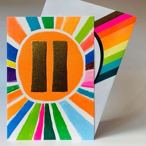 A bright 11th birthday card. Neon bright star burst with a big neon orange circle with a gold 11