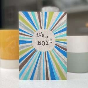 A lovely rainbow crayon card with the words It's a boy printed in the centre of it.