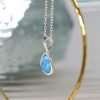 Sterling silver and white synthetic blue opal teardrop shaped pendant on a fine sterling silver chain