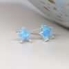 Sterling silver star stud earrings with deep cut synthetic blue star shapes in claw settings
