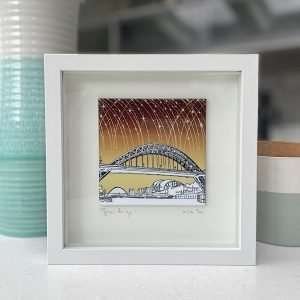 A fantastic Colourful Tyne Bridge tile picture with a pen and ink design and yellow and brown background, set in a box frame.