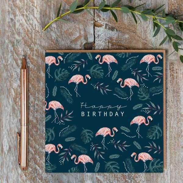 A navy birthday card with pink flamingos