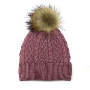 A dusky pink fleece lined, cable knit bobble hat in wool mix with a natural fuax fur pom pom