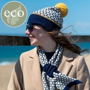 A popcorn knit bobble hat and pull through short scarf set. The hat and scarf have matching fluffy pom pom and trim in mustard