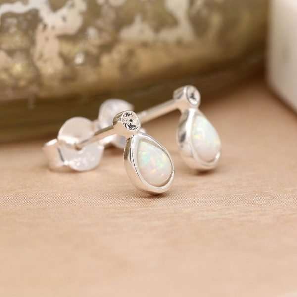 Sterling silver teardrop shaped stud earrings with white synthetic opals, each topped with a tiny clear crystal and fastened with sterling silver butterfly clasps