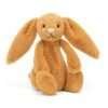 A cuddly golden bunny with long ears anda pink nose