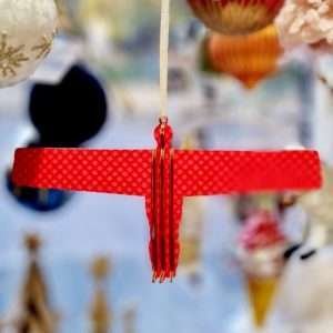 A cranberry red wooden angel of the north hanging decoration