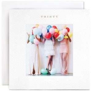 A cute photographic card with an image of 3 women all holding lots of balloons in front of their faces with the word Thirty printed at the top of the card