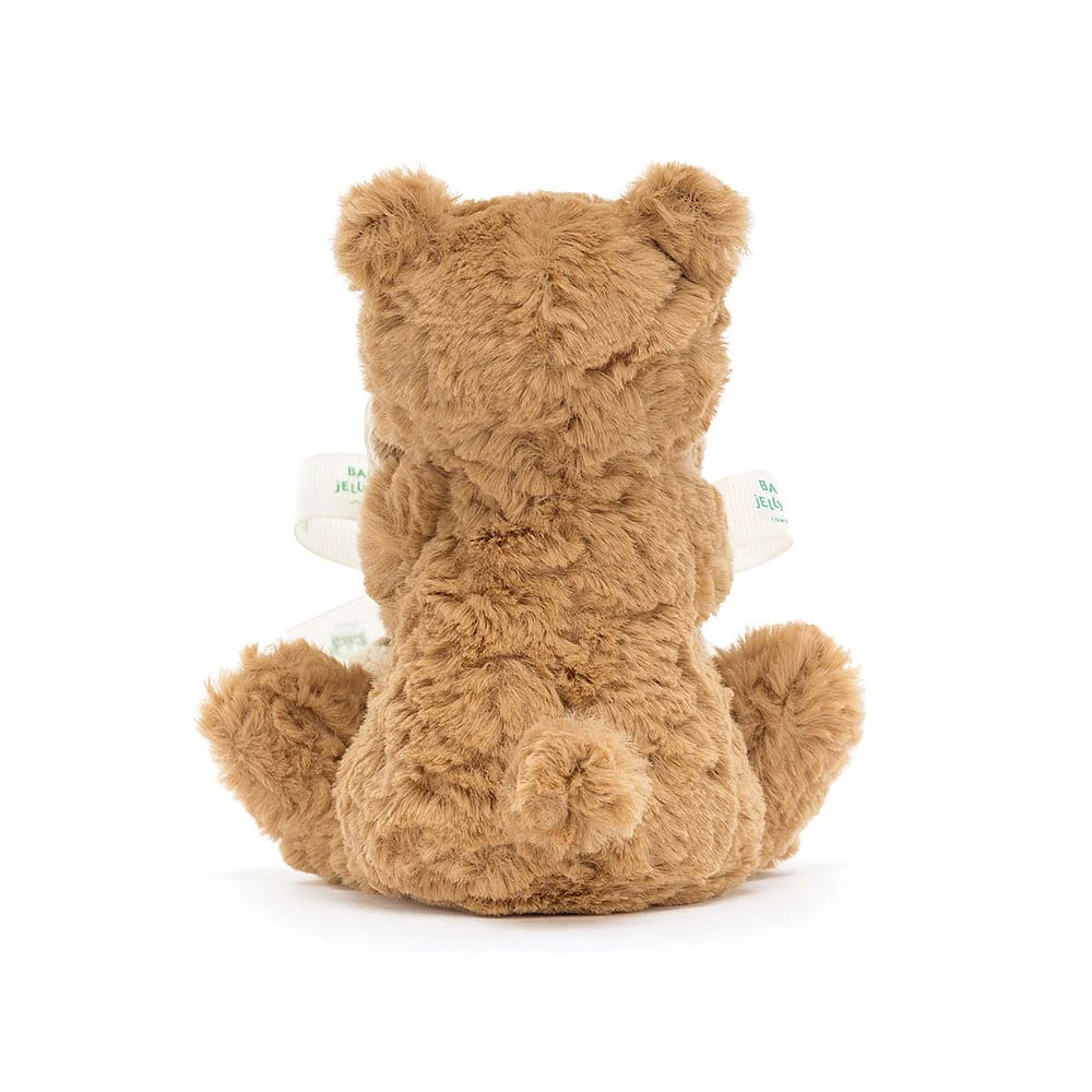 A brown softly textured toy bear is hugging an un-stuffed square shaped soother blanket