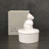 A white porcelain trinket dish with a cat on the lid in a box printed with friends leave paw prints on your heart