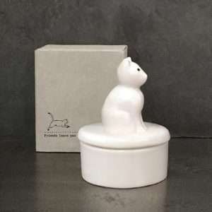 A white porcelain trinket dish with a cat on the lid in a box printed with friends leave paw prints on your heart