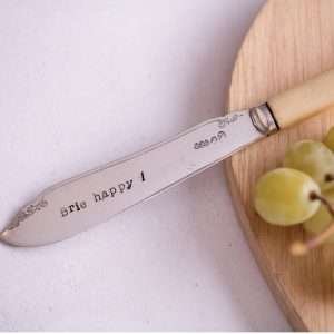 An antique bone handled knife hand stamped with BRIE HAPPY! A hand stamped cheese knife
