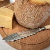 An antique bone handled knife hand stamped with BRIE HAPPY! A hand stamped cheese knife on a cheese board with a cheese