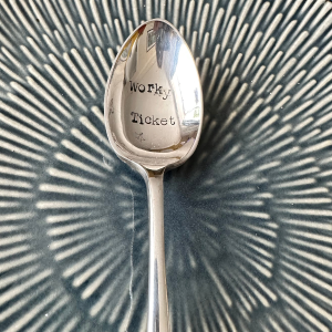 A teaspoon with the words Worky Ticket engraved into it