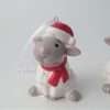 A ceramic sheep in a red santa hat and red scarf tree decoration