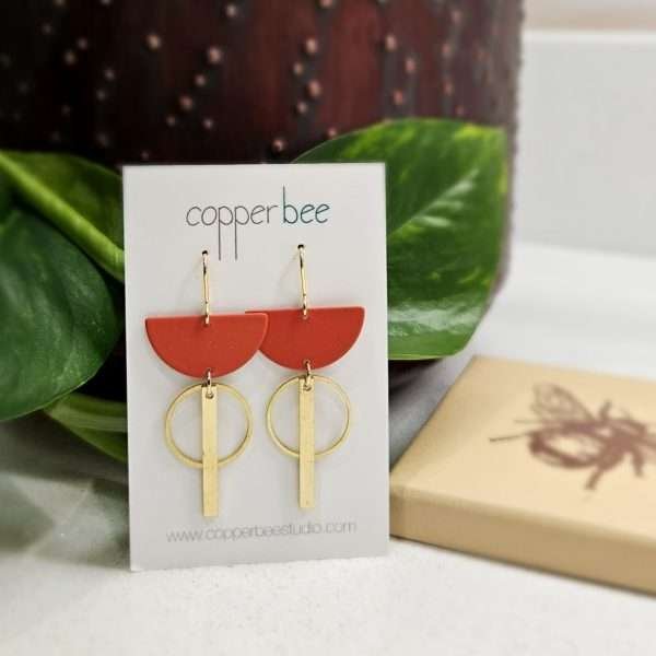 earings with a rust semi circle a brass hoop and a brass rod