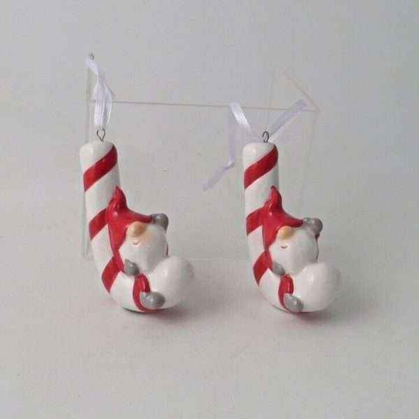 A ceramic candy cane wwith a little gonk sitting on hanging decoration