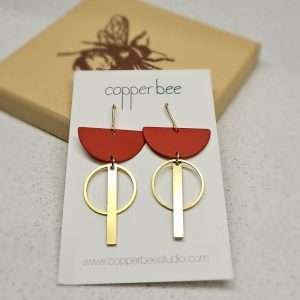 earings with a rust semi circle a brass hoop and a brass rod
