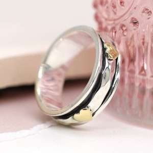 Sterling silver spinning ring with hammered moving band and multiple brass hearts